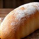 Icoon van een versgebakken brood op een planken tafel met bloem stof